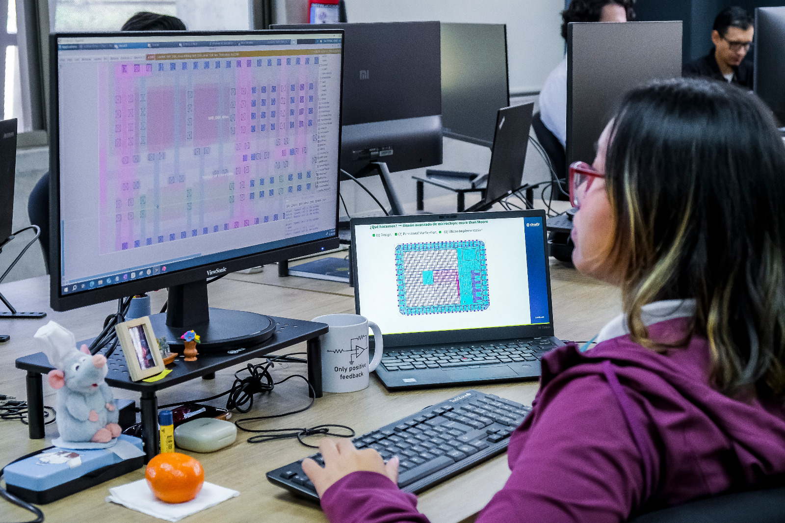 Estudiante trabaja en el diseño de un microchip frente a estaciones de cómputo